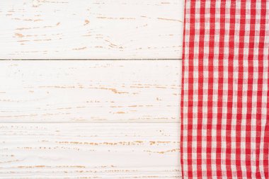 Kareli gingham masa örtüsü peçetesi rustik ahşap tahta masa arka planında, üst manzara, dizayn için düz yatış. Kenarında peçete olan beyaz ahşap zemin