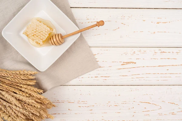 ハニカム 白い正方形のプレート上に蜂蜜とハニカムの新鮮な作品 小麦と 有機的な季節の食べ物やコピースペース — ストック写真