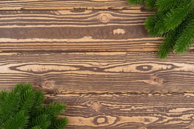 Yeni yıl geçmişi. Ahşap bir masada ladin dalları. Yeni yıl ağacı için süsler. Noel konsepti üst görünümü, metin için boşluk kopyala