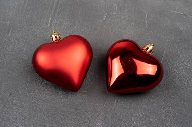 Gri beton arka planda iki kırmızı kalp, Noel süsü, hediye kartı için arka plan, yakın görüş. Sevgililer Günü