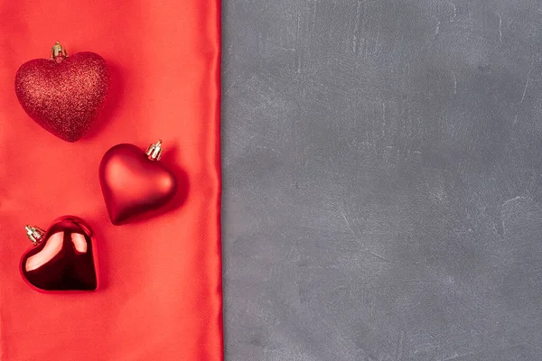 Sevgililer Günü 'nde fotokopi alanı vardı. Gri bir arka planda ve kırmızı bir yay, kırmızı top kalpler, top şeklinde kalpler, kırmızı saten dokular. Noel konsepti