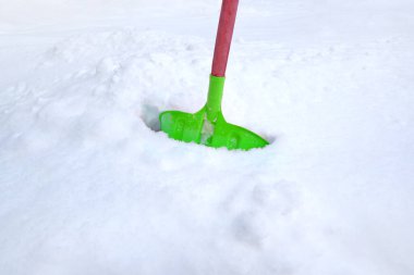 Kar temizleme küreği kar yığınında duruyor.