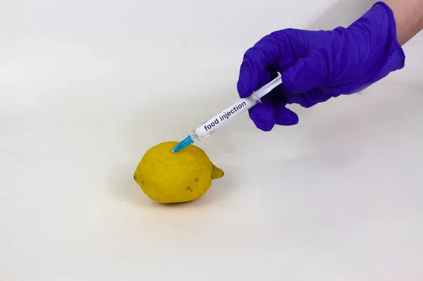 Eldivenin üzerine gıda enjeksiyonu enjeksiyonu enjekte edilmiş limon yakın çekim görüntüsü