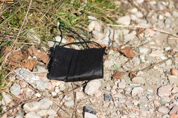 Siyah bir tıbbi yüz maskesi doğayı kirletiyor.