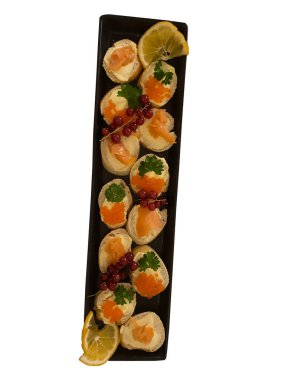 Somonlu sandviçler, somon havyarı ve kırmızı kuş üzümü beyaz arka planda izole edilmiş.