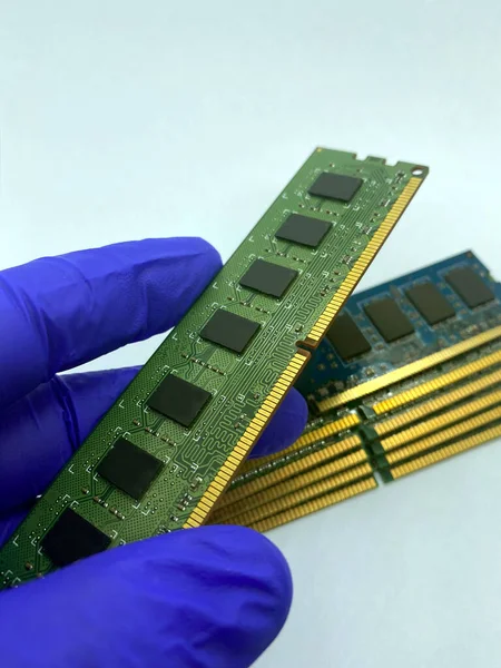 RAM çipi, beyaz arkaplanda izole edilmiş RAM çiplerine karşı eldiven takılı kaldı