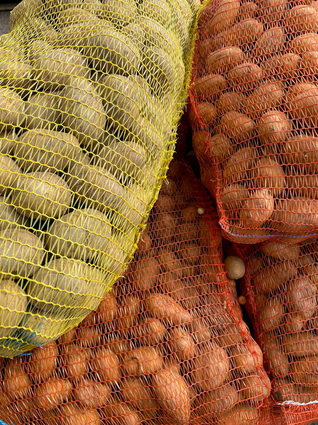 Белый и красный картофель в мешках крупным планом с выборочным фокусом на переднем плане