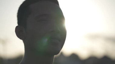 Portrait Asian Indonesian Male Hopeful Thoughtful and Confident Face Illuminated by The Sun in Dramatic Slow Motion
