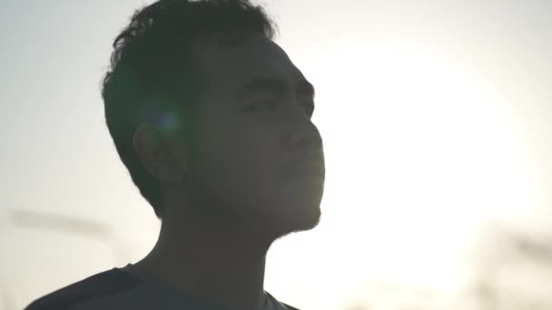 ポートレート アジアの男性劇的なスローモーションで太陽に照らされた希望に満ちた自信に満ちた顔 — ストック動画