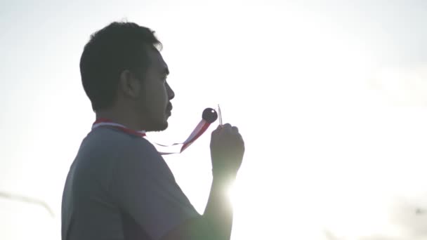Silhouette Portrait Champion Gewinner Male Kissing Gold Medaille Dramatic Sun — Stockvideo
