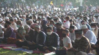 Bali, Indonesia - May 2 2022: Muslims Gather Celebrate Eid al-Fitr Salah Praying in a Park in Denpasar