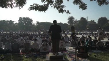 Bali, Indonesia - May 2 2022: Muslims Gather Celebrate Eid al-Fitr Salah Praying in a Park in Denpasar