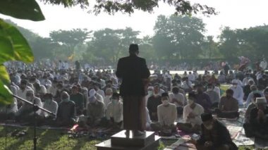 Bali, Indonesia - May 2 2022: Muslims Gather Celebrate Eid al-Fitr Salah Praying in a Park in Denpasar
