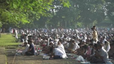 Bali, Indonesia - May 2 2022: Muslims Gather Celebrate Eid al-Fitr Salah Praying in a Park in Denpasar
