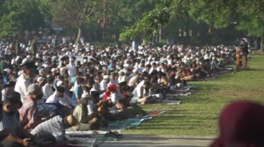 Bali, Indonesia - May 2 2022: Muslims Gather Celebrate Eid al-Fitr Salah Praying in a Park in Denpasar