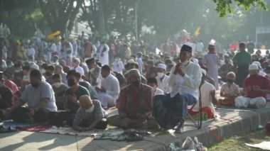 Bali, Indonesia - May 2 2022: Muslims Gather Celebrate Eid al-Fitr Salah Praying in a Park in Denpasar