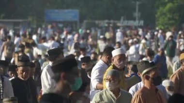 Bali, Indonesia - May 2 2022: Muslims Gather Celebrate Eid al-Fitr Salah Praying in a Park in Denpasar