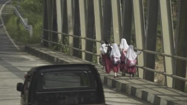 インドネシア西ジャワ州ガルート インドネシアの小学生赤白制服道路脇を歩く — ストック動画