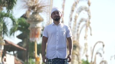 Galungan Kuningan Günü 'nde Penjors Dekoratif Bambu Polonyalıları Tarafından Bali Caddesi' nde Geleneksel Tebrik ve Gülümseme ile Endonezyalı Balerin Adam
