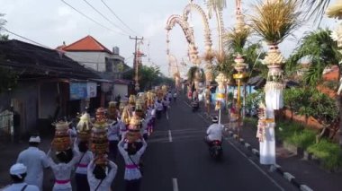 Bali, Endonezya - Mapeed Geleneksel Hava Aracı Kadınlar, Galungan Kuningan Günü sırasında Penjor Penjors Dekoratif Bambu Polonyalıları tarafından süslenmiş Kerobokan Caddesi 'nde Gebogan Meyvesini Taşır
