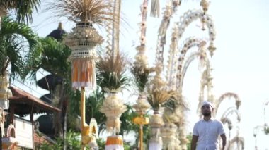 Galungan Kuningan Günü 'nde Penjors Dekoratif Bambu Polonyalılarla süslenmiş Bali Caddesi' nde Geleneksel Kıyafet Yürüyüşü yapan Endonezyalı Balerin Adam