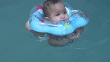 Sevimli küçük Asyalı Bebek 1 yaşında Yürüyen Çocuk Mavi Havuz Yüzen Çocuk Yüzmeyi Yavaş Çekimde Öğrenin