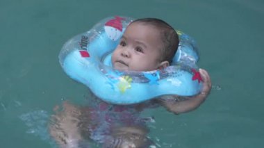 Sevimli küçük Asyalı Bebek 1 yaşında Yürüyen Çocuk Mavi Havuz Yüzen Çocuk Yüzmeyi Yavaş Çekimde Öğrenin