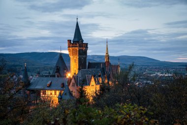 Gün batımında Wernigerode Kalesi 'nde mistik bir bina. Şehir görünümü