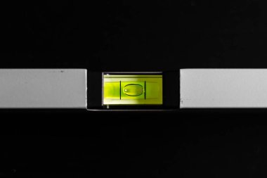 İnşaatta siyah zemin üzerindeki sarı bina seviyesi kullanılıyor