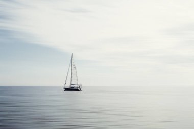 Sakin sularda yüzen yelkenli.