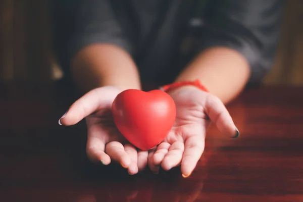 Mulher mãos segurando coração vermelho — Fotografia de Stock