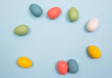 Paskalya arkaplanı, ahşap üzerinde el yapımı renkli yumurtalar parlak mavi bir arka plan. Çerçeve ve kopyala. 