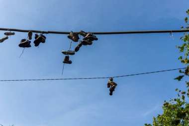 Slovenya 'nın Ljubljana kentindeki Metelkova' da elektrik kablolarında asılı farklı spor ayakkabıları