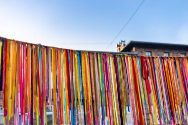 Polonya, Silezya, Katowice 'deki Nikiszowiec tarihi bölgesinde binanın dışında asılı renkli kurdelelerden yapılmıştır. Arka planda mavi gökyüzü. 