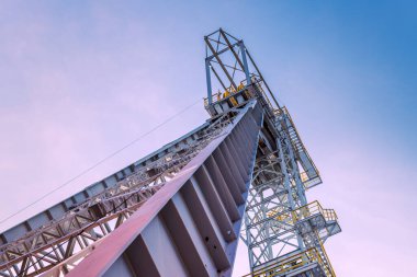 Maden ocağı kulesi 'Krystyn' in eski kömür madeni 'Michal' in Siemianotwo 'da, Silesia, Polonya' nın aşağısında pembe bulutlarla mavi gökyüzüne karşı görüldü. 