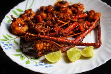 Lezzetli karides körisi tabakta, siyah arka planda.