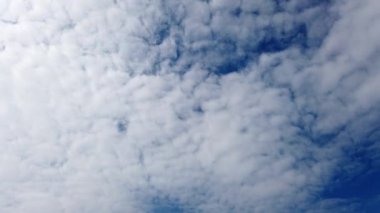 Mavi gökyüzünde hızla hareket eden beyaz bulutlar zaman aşımına uğrar