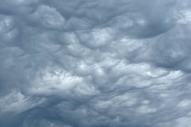 Gökteki mavi ve koyu gri ağır bulutlar fırtınadan önce. Dramatik arkaplan ya da duvar kağıdı. Tehlikeli ve doğal bir geçmişi var. Fırtınanın ya da felaketin öncesinde. Yüksek kalite fotoğraf