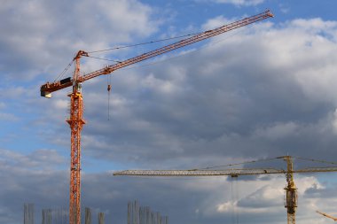 Mavi bulutlu gökyüzü ile ağır inşaat vinçleri 