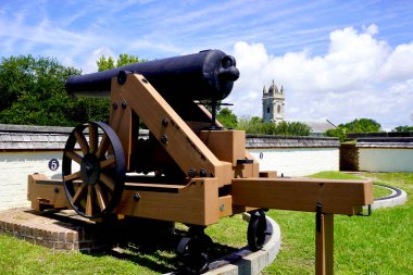 Sullivan's Island, South Carolina: Fort Moultrie National Historic Park. Model 1829 32-pounder gun (cannon)  and Stella Maris Catholic Church. Fort defended Charleston Harbor through many wars.