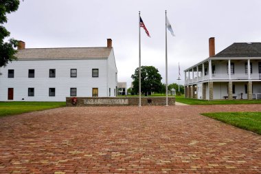 Fort Scott, Kansas: Fort Scott National Historic Site. Entrance to frontier outpost. Sign with American and Kanas flags, infantry barracks and visitor center in the old hospital. Brick walkway. 