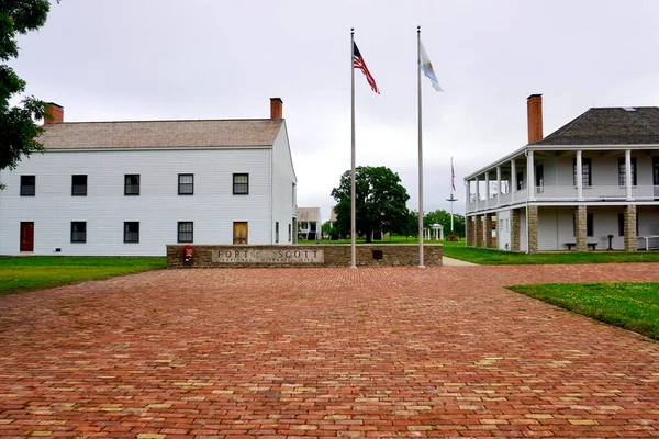 Fort Scott, Kansas: Fort Scott National Historic Site. Entrance to frontier outpost. Sign with American and Kanas flags, infantry barracks and visitor center in the old hospital. Brick walkway. 