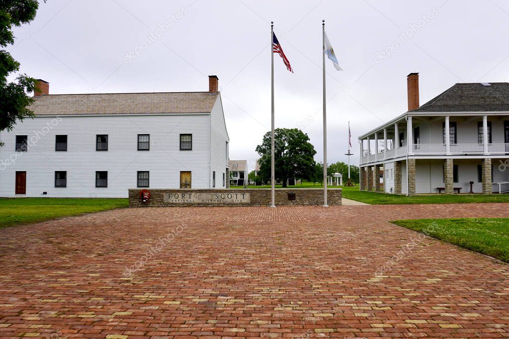 Fort Scott, Kansas: Fort Scott National Historic Site. Entrance to frontier outpost. Sign with American and Kanas flags, infantry barracks and visitor center in the old hospital. Brick walkway. 