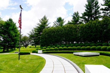 Herbert Hoover Ulusal Tarih Bölgesi Batı Şubesi, Iowa. Başkan Hoover ve Lou Henry Hoover 'ın mezarı. İki mermer defter taşı, yarım daire şeklinde bir arazide bayrak ile mezarları işaretliyor..