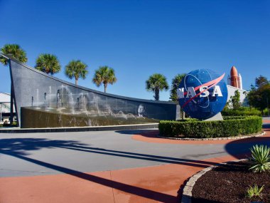Kennedy Uzay Merkezi, Florida, ABD: John F. Kennedy Çeşmesi, Mavi NASA Logo Küresi, Uzay Mekiği Atlantis dış tankı ve katı roket iticileri ile giriş Plaza. 