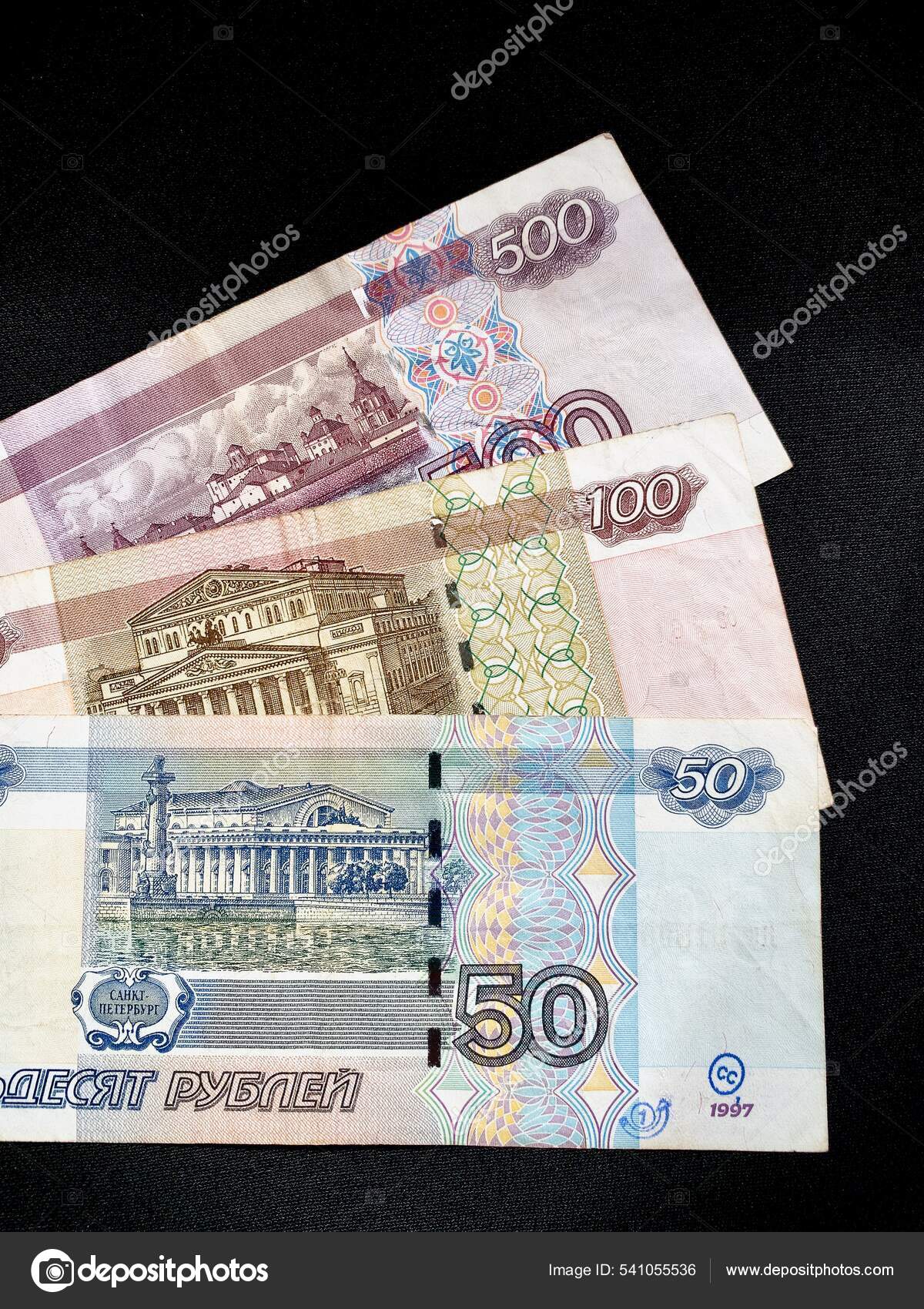 俄罗斯卢布或卢布是俄罗斯联邦的货币与建筑物中的50 100和500个音符相反老圣彼得堡证券交易所和屋顶专栏作家—— 库存社论照片© EWYMedia  #541055536