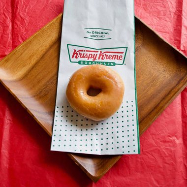 Krispy Kreme logolu orijinal kremalı donut. Kırmızı ve yeşil logo. Krispy Kreme Doughnuts, JAB Holding Şirketi 'ne ait bir donut şirketidir..