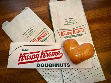 Krispy Kreme orijinal kalp donutu ve Krispy Kreme logosu. Kırmızı ve yeşil logo. Krispy Kreme Doughnuts, Inc. bir Amerikan donut şirketidir. Kalp şeklinde donut..