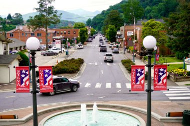 Sylva, Kuzey Carolina: Tarihi adliye merdivenlerinden görüntü. Fountain ve West Main Caddesi. Blue Ridge Inn, Wells Fargo Bankası, Sylva Polis Departmanı. Kasabayı saran Blue Ridge Dağları.