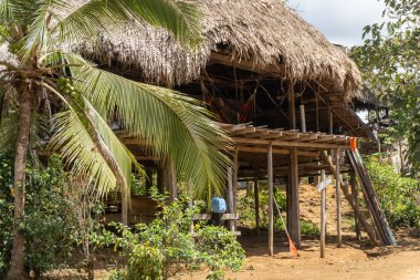 Panama 'daki Embera Puru Embera köyü. Geleneksel Ember evi, ayaklıklar üzerinde yerden yükselen, palmiye yapraklarından yapılmış sazdan çatılı bir konuttur. Evin altında depolanan dış motor.